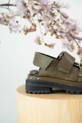 Sandalias de cuero color verde oliva con suela track y hebillas plateadas.