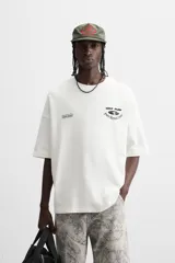 Sudadera relaxed fit color blanco de algodón con cuello redondo y manga corta. Presenta estampados de gráficos y textos combinados a contraste en delantero y espalda.