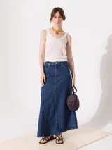 Pollera larga hasta los tobillos, confeccionada en denim de algodón, con desgastes en las costuras para un look vintage.