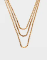 Collar dorado de tres cadenas finas con eslabones cuadrados y cierre de mosquetón.
