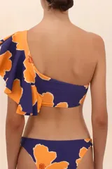 Top de bikini asimétrico con estampado floral en tonos naranja y azul, con un solo hombro y volado grande.