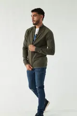 Campera tejida azul marino con cuello alto, cierre frontal y puños acanalados con detalle de línea roja.