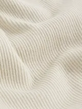 Cárdigan color crema de tejido de canalé fino, con cierre de botones asimétrico y logo de Calvin Klein bordado en el bajo.