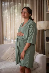 Bata tipo kimono de algodón color blanco hueso, con textura acanalada vertical. Presenta un cruce frontal asegurado con un lazo a la cintura y mangas anchas de largo al codo.