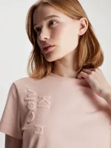 Remera rosa de algodón con cuello redondo y mangas cortas. Presenta múltiples logos de Calvin Klein Jeans en relieve.
