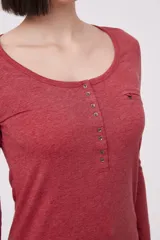 Remera de manga larga entallada en color blanco, confeccionada en algodón. Presenta cuello redondo con una hilera de botones frontales y un pequeño bolsillo en el pecho con detalle de botón.