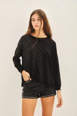 Sweater negro de moldería holgada, liviano y de caída relajada. Con aplicación de tachas termofijadas que expanden desde el hombro hacia el bajo ruedo de forma radial.
