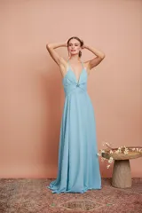 Vestido largo de fiesta celeste, con escote en V profundo y breteles finos. Presenta un detalle de frunce con aplique brillante en el centro del busto y falda acampanada.