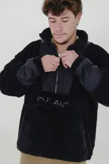 Canguro negro de polar con cierre de cremallera parcial, cuello alto y mangas largas con puños de tela lisa. Tiene un bolsillo tipo canguro con el logo de la marca bordado en el frente.