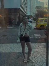 Camisa negra con estampado de lunares blancos, de manga larga y cuello clásico.