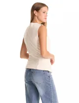 Chaleco sastrero color crema, con cuello redondo, cierre frontal con botones forrados y bolsillos simulados. El ruedo frontal tiene un acabado en pico.