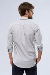 Camisa celeste a rayas verticales, de manga larga con opción de enrollar, corte slim fit, con bolsillo en el pecho y confeccionada en algodón.