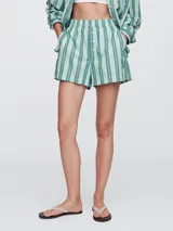 Short de tela con rayas verticales verdes y blancas, cintura elastizada con botones decorativos.