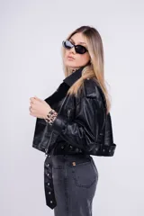 Campera de cuero sintético negra, con cierre cruzado, cuello con solapas y cinturón ajustable.
