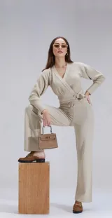 Conjunto de buzo cruzado de manga larga y pantalón con cintura ajustable, confeccionado en tricot color beige.