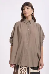 Camisa color visón, de corte holgado y manga larga.