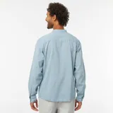 Camisa celeste de manga larga con cuello mao y cierre parcial con botones.