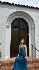 Vestido largo negro con escote en V, cut outs laterales bajo el busto y breteles finos cruzados y atados en la espalda.