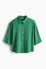Camisa verde de lino y viscosa, de corte holgado, con cuello clásico, cierre frontal con botones y mangas 3/4.