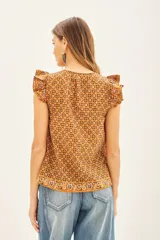 Camisa color marrón con estampado geométrico, escote redondo, mangas cortas con volados estampados y tajos laterales.