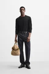 Jersey negro de lana con acabado mercerizado, corte relaxed fit, cuello redondo y manga larga con terminaciones en rib.