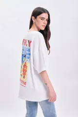 Remera blanca de corte amplio con mangas cortas y estampado en la espalda con la palabra "Italy", un aperitivo, una copa y la frase "La dolce vita".