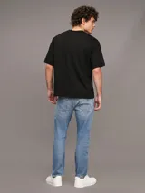 Pantalón de jean celeste, corte slim tapered, con bragueta con cremallera y diseño de cinco bolsillos. Calvin Klein.