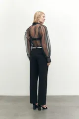Camisa de organza color negro, con mangas largas abullonadas y cierre frontal.