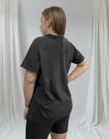 Remera negra con efecto gastado, cuello en V y estampado de cerezas con la frase "Cherry Pain".