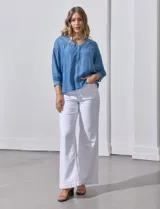 Blusa celeste de lyocell con cuello a la base y escote en V con apertura central y botones. Manga ¾ con puño y botón.