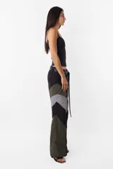 Pantalón negro de corte recto y tiro medio, con recortes en las piernas con detalle de vivo. Cintura con presillas y cinto correa con broche plástico incluido.