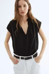 Blusa negra de corte holgado en tejido liviano de algodón y viscosa. Modelo de manga japonesa con escote en V y cuello mao con frunces adelante y atrás. Bajo redondeado.