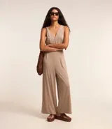 Mono pantalón color beige, de viscosa sostenible, con escote en V cruzado en el frente y en la espalda. Tiene lazo en la cintura.