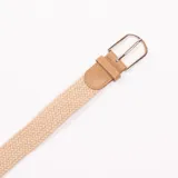 Cinturón beige trenzado con hebilla metálica plateada y apliques de cuero sintético marrón.