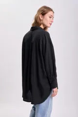 Camisa negra de liocel con cuello clásico, cierre frontal con botones, manga larga y bolsillo de parche en el pecho.