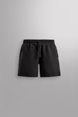 Bermudas jogger negras confeccionadas en tejido de algodón con interior de rizo. Cintura elástica ajustable con cordón y bolsillos laterales en la cadera.