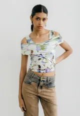 Top de jersey con estampado abstracto en tonos celeste, azul y negro. Diseño con hombros descubiertos y corte cruzado en el frente.