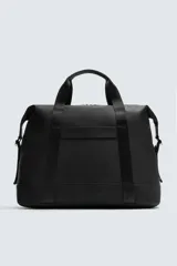 Bolso de viaje negro con acabado texturizado, compartimento principal con cierre de cremallera, bolsillo plano trasero con cierre de cremallera, banda de sujeción para equipaje y asa de hombro removible y ajustable.