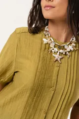 Blusa color verde oliva con cuello mao, mangas cortas abullonadas y cierre frontal con botones.