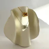 Collar dorado con dije en forma de rosa.