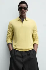 Polo de punto color amarillo claro, corte regular fit, tejido en hilatura con mezcla de algodón y lyocell. Cuello solapa con cierre frontal de botonadura y manga larga. Acabados en rib.