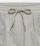 Bermuda deportiva gris con cintura elástica ajustable con cordón, bolsillos laterales y aberturas laterales en el bajo.