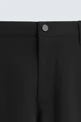 Pantalón largo de vestir gris claro con estampado de cuadros, corte slim fit y cintura elástica. Confeccionado en tejido con alta elasticidad, bolsillos frontales y cierre frontal con cremallera y botón.