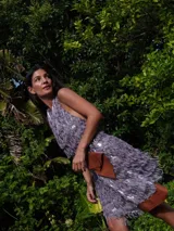 Vestido corto con cuello halter, espalda descubierta, flecos y lentejuelas.