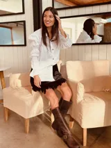 Minifalda con estampado geométrico en tonos amarillo, negro y gris, con detalle de plumas en el ruedo.