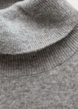 Top gris de lana sin mangas con cuello alto.