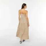 Vestido largo color beige con tirantes finos, corte imperio y falda con capas.