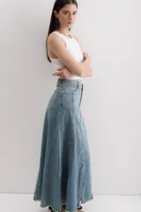 Falda larga de jean celeste, con corte sirena y abertura frontal.