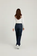 Pantalón jean negro de calce medio, tiro alto y corte ancho tipo "flare" o "bota".