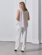 Camisa sin mangas de lino a rayas verticales azules y blancas, con cuello con solapa, escote en V, abertura central con botones y bolsillo en el pecho.